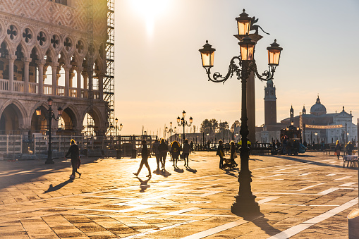 Vintage street lamp on Piazza San Marco square with Saint Mark's Campanile in the background against sky at sunset in Venice,Italy