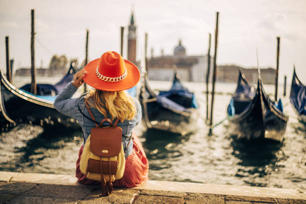 istock Blond woman with backpack wearing hat and exploring Venice 1466766837
