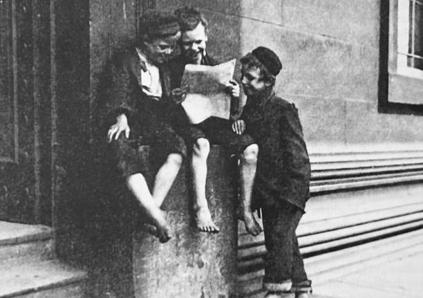 istock Street boys reading a newspaper and laughing at a building entrance 1466767307