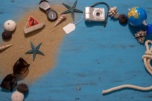 Vacation concept. Seashells and old vintage camera on blue background, copy space