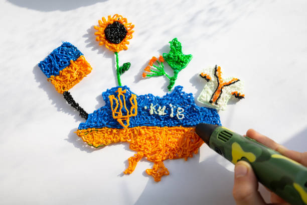 Ukrainian symbols from plastic 3d pen making child: flag, sunflower, trident, map, shirt.