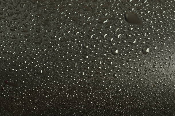 istock Close-up water droplets on black background, textured surface 1466771336