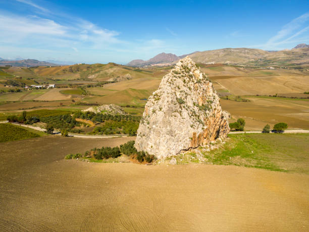 Scenic view of agricultural field and huge rock,Sicily,Italy