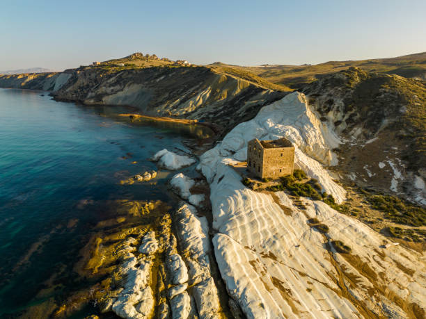 Aerial view of white beach with old ruins of abandoned house on white cliff,Sicily,Italy