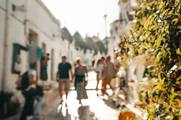 Tourists exploring trulli houses in old town at Alberobello