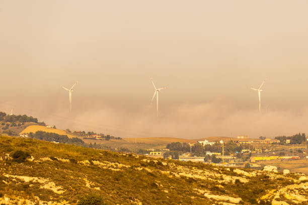 Wind turbines on agricultural landscape with sky in background on sunny day