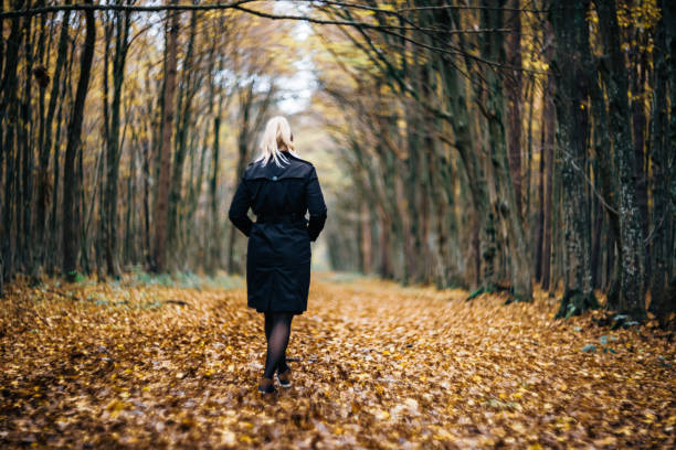 istock Beautiful woman walking at autumn forest 1466772116