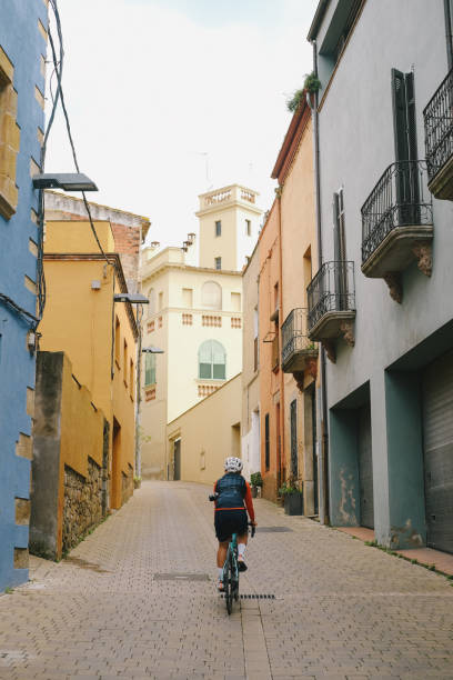 istock Young woman bicycles through old town 1466772467