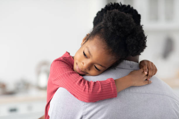 istock Smiling little black girl hugging her daddy 1466775574