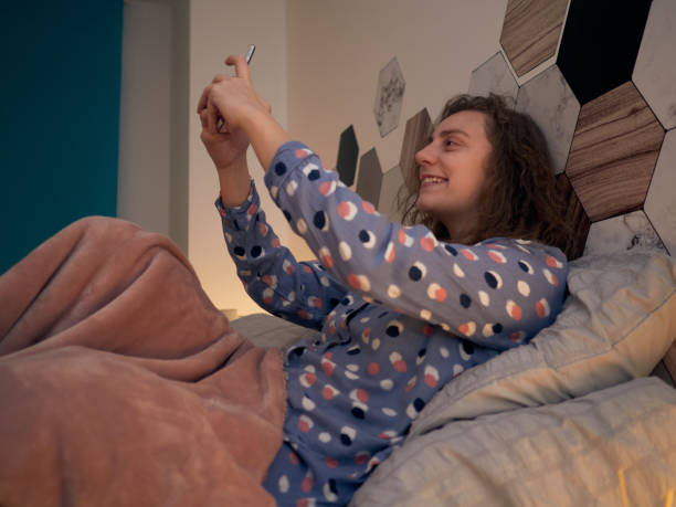 istock Woman on bed taking a selfie with the smartphone 1466776427