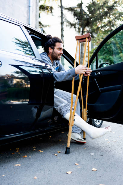 istock A young man with a broken leg is trying to use a car. 1466776616