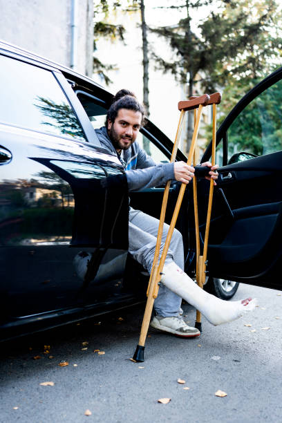 istock A young man with a broken leg is trying to use a car. 1466776619