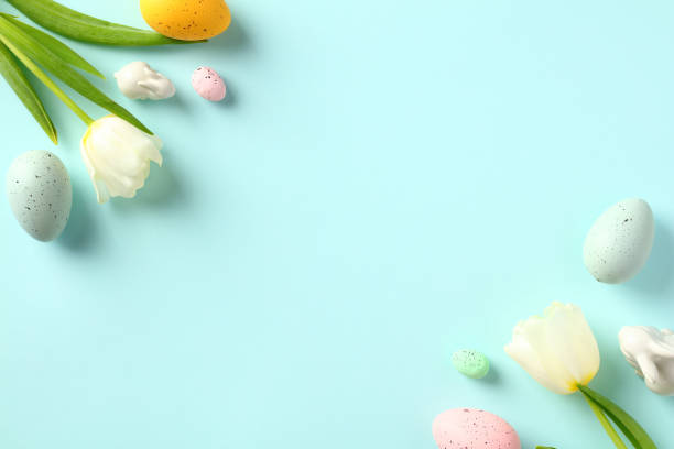istock Happy Easter flat lay composition. Frame of Easter eggs with tulips on pastel blue background. Happy Easter card design, template. 1466777789