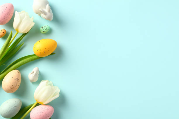 istock Happy Easter greeting card template. Colorful Easter eggs with tulips, bunny decorations on light blue background. 1466777837
