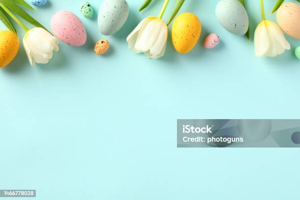 Happy Easter Concept Frame Top Border Made Of Tulips Spring Flowers And Colorful Easter Eggs On Light Blue Background Stock Photo - Download Image Now