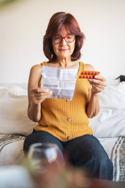 istock Latin woman checking patient information leaflet for her medicine. 1466780234
