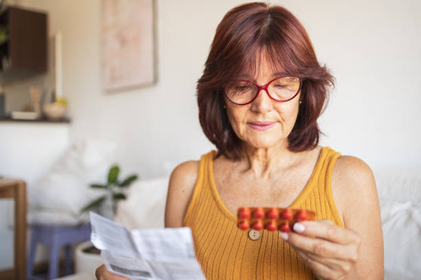 Latin woman checking patient information leaflet for her medicine. stock photo