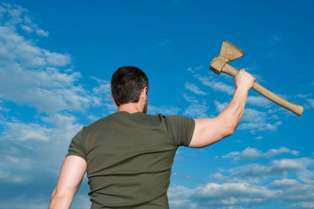 back view of man with axe. man hold ax. brutal man on sky background.