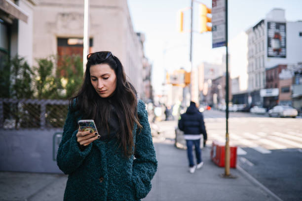 istock commuter checking apps on the streets of NYC 1466785291