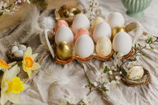 istock Stylish easter eggs and blooming spring flowers on rustic fabric background. Happy Easter! Rustic easter still life. Modern eggs in tray and wildflowers 1466785535