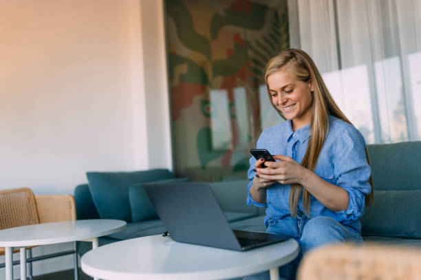 istock Happy woman working at the office while using a mobile phone. 1466789723