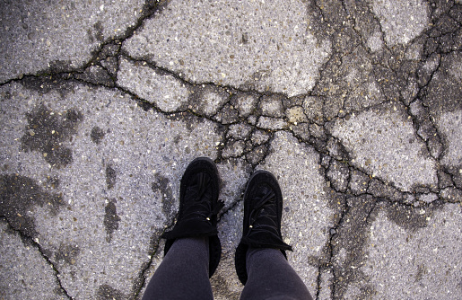 Detail of a young person in an old and abandoned road, exploration