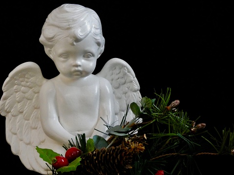 PRAYING PORCELAIN WHITE ANGEL - \nCHILD STATUE WITH WINGS ON BLACK BACKGROUND & WINTER FLORAL