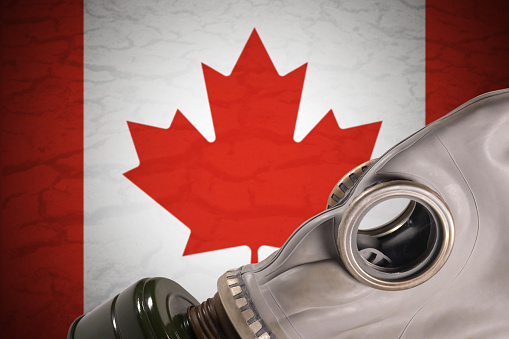 Gas mask on canada flag background, environmental pollution concept