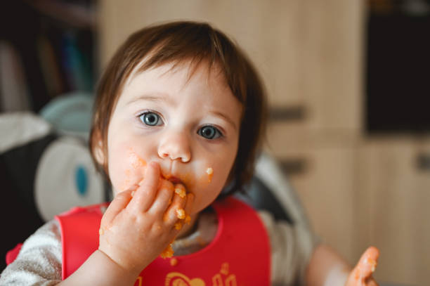 istock Messy baby eats and tastes with fingers. 1466801272