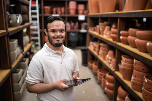 istock Portrait of a young special needs man working using digital tablet in a garden center 1466802270