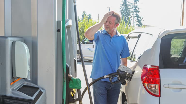 Man at Fuel Pump Feeling Stressed