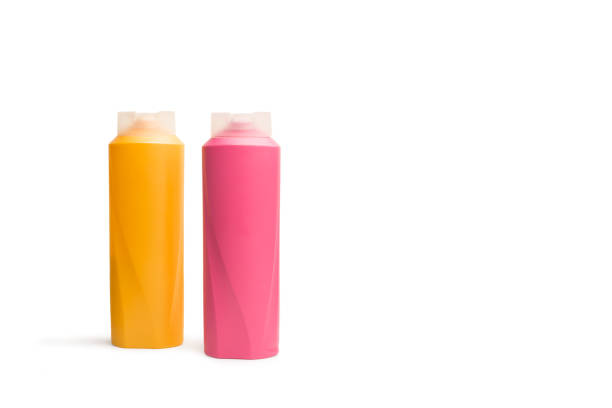 istock Pink and orange shampoo bottles on a white background 1466803189