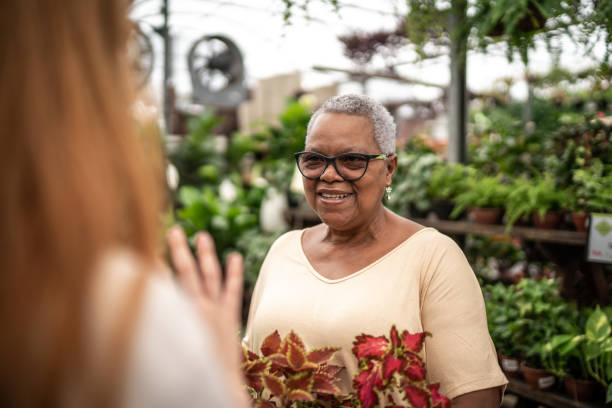 Senior woman buying plants in a garden center