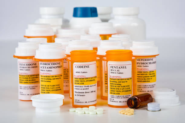 médicaments d’ordonnance à risque dans des contenants sur table - narcotic prescription medicine pill bottle medicine photos et images de collection