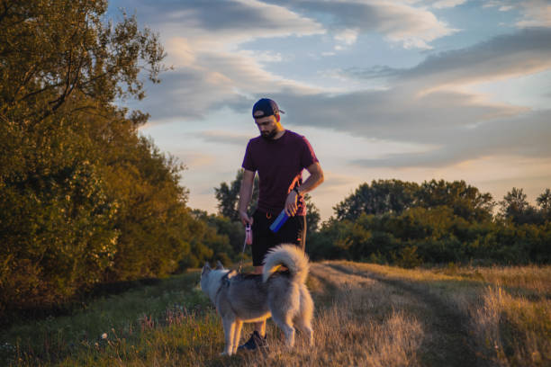 istock Young man standing with his husky dog in nature. 1466812871