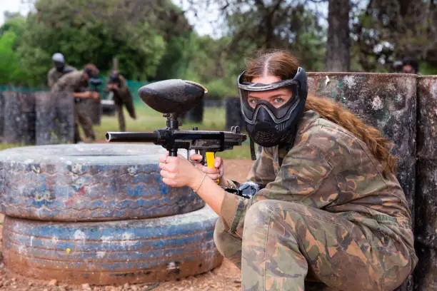 Photo of Portrait of girl in camouflage on paintball field