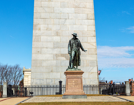 Boston, Massachusetts, USA - February 15, 2023: Colonel William H. Prescott statue in front of the the Bunker Hill Monument, a monument erected at the site of the Battle of Bunker Hill in Boston, which was among the first major battles between the Red Coats and Patriots in the American Revolutionary War. According to popular stories, Prescott coined the famous Revolutionary War phrase \
