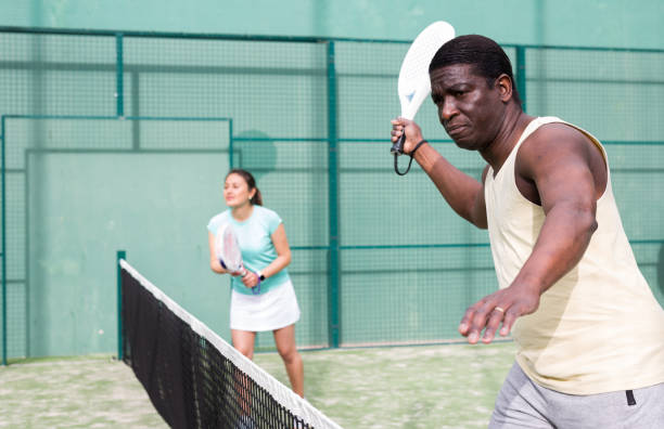 sporty emotional man playing doubles paddle tennis - hoby imagens e fotografias de stock