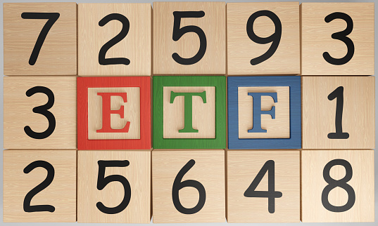 Numerical wooden blocks surrounding alphabetic ETF toy pieces. Illustration of the concept of exchange-traded fund investment and selection