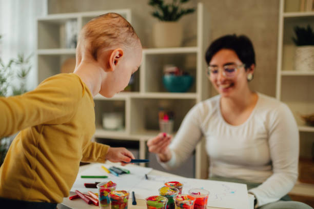 istock Mother and son drawing with crayons at home and having education 1466821101