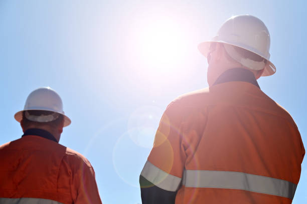 Blue collar workers isloate dagaint blue sky with sun flare stock photo