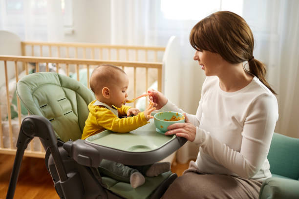 istock Mother feeding her baby son with spoon. 1466827047