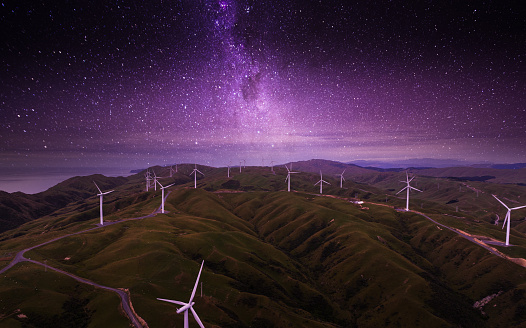 Wind farm at night with sky full of stars in Wellington, New Zealand.