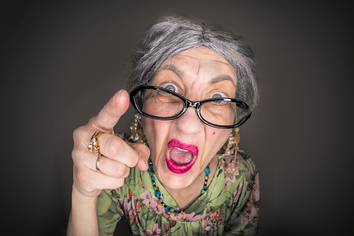 A funny fisheye image of a grumpy old lady yelling and pointing her finger.