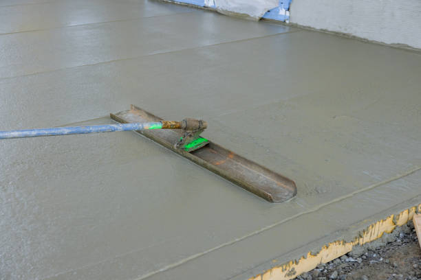 istock The worker was pouring concrete on the sidewalk using a long trowel on a wet cement surface, and he was leveling it as he went. 1466830726