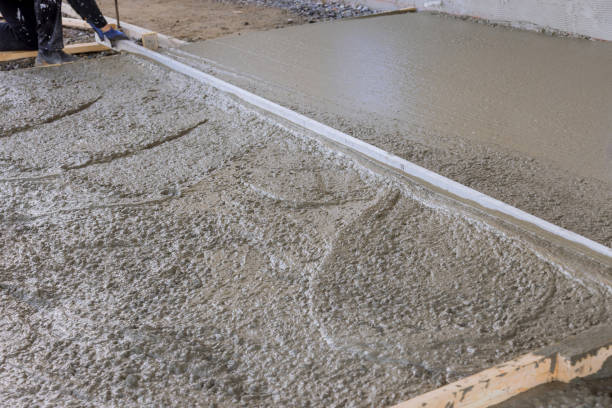 istock A construction worker in leveling an poured concrete with using long trowels is wet cement sidewalk 1466830731