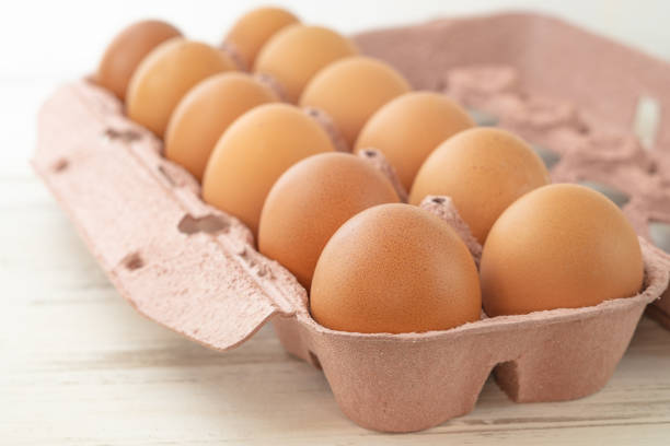 istock Open egg box with twelve brown eggs isolated on white background with clipping path. Fresh organic chicken eggs in carton pack or egg container with copy space. Recycled cardboard box with a dozen egg 1466835766