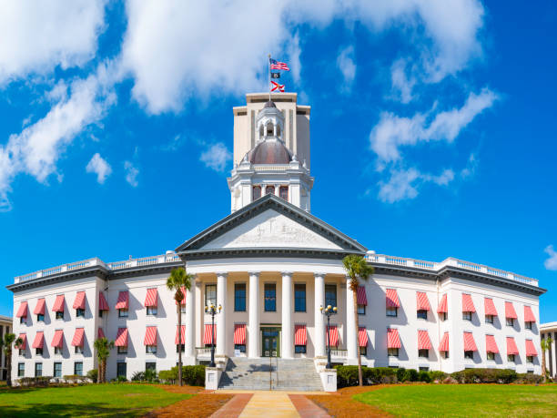 histórico edificio del capitolio del estado de florida con toldos a rayas de colores brillantes, cúpula de estilo clásico y banderas estadounidenses y del estado de florida en tallahassee - southern alberta fotografías e imágenes de stock