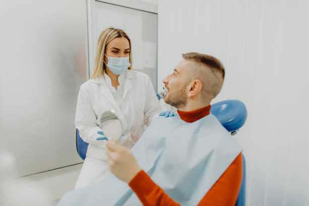 istock Happy male patient talking with his dentist 1466836793