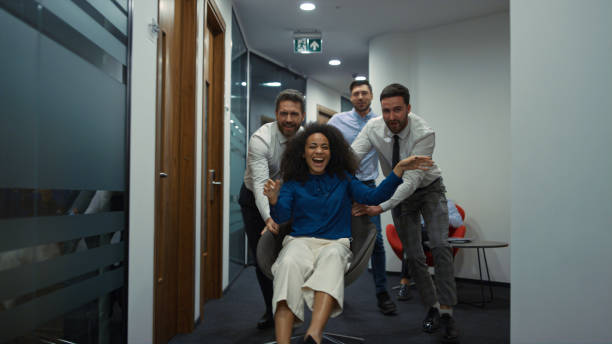 istock Business group racing chair having fun party in diverse office workplace hallway 1466838424